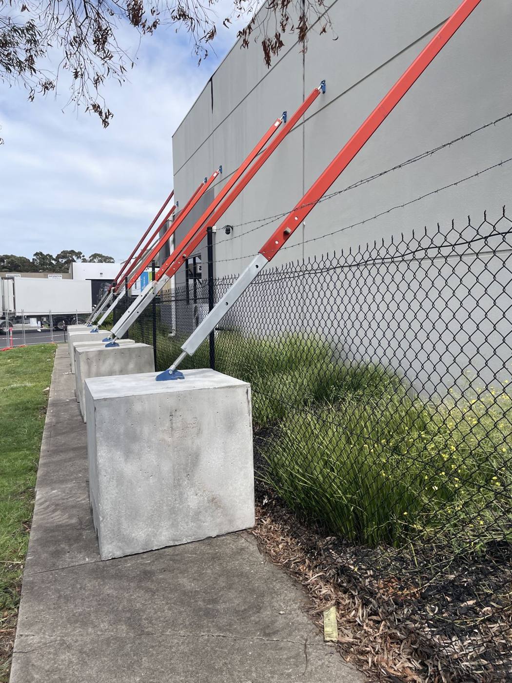 Row of raking props on concrete blocks supporting a warehouse wall