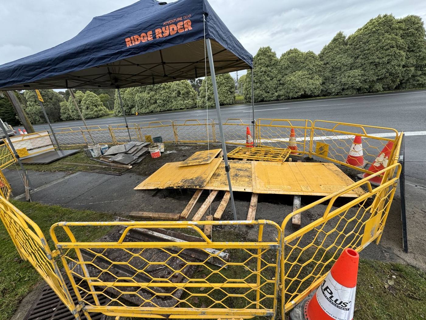 Roadside civil works site with barriers and shade marquee