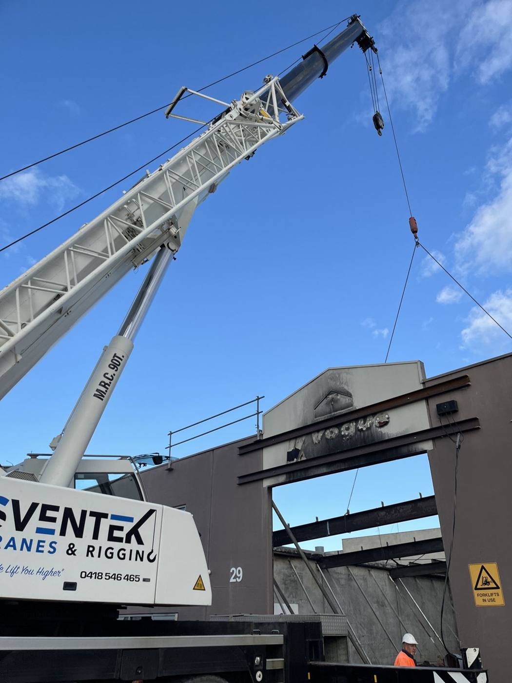 Mobile crane set up beside a commercial building for panel works