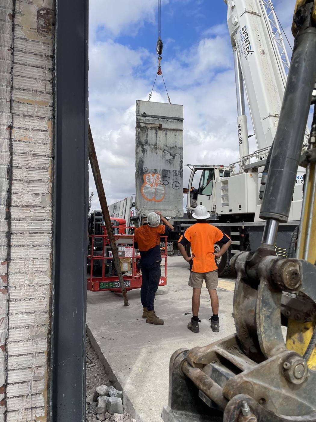 Crew guiding a precast panel into position