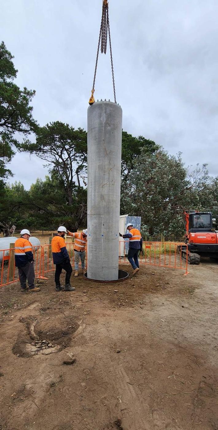 Crew guiding a monopole butt section into place