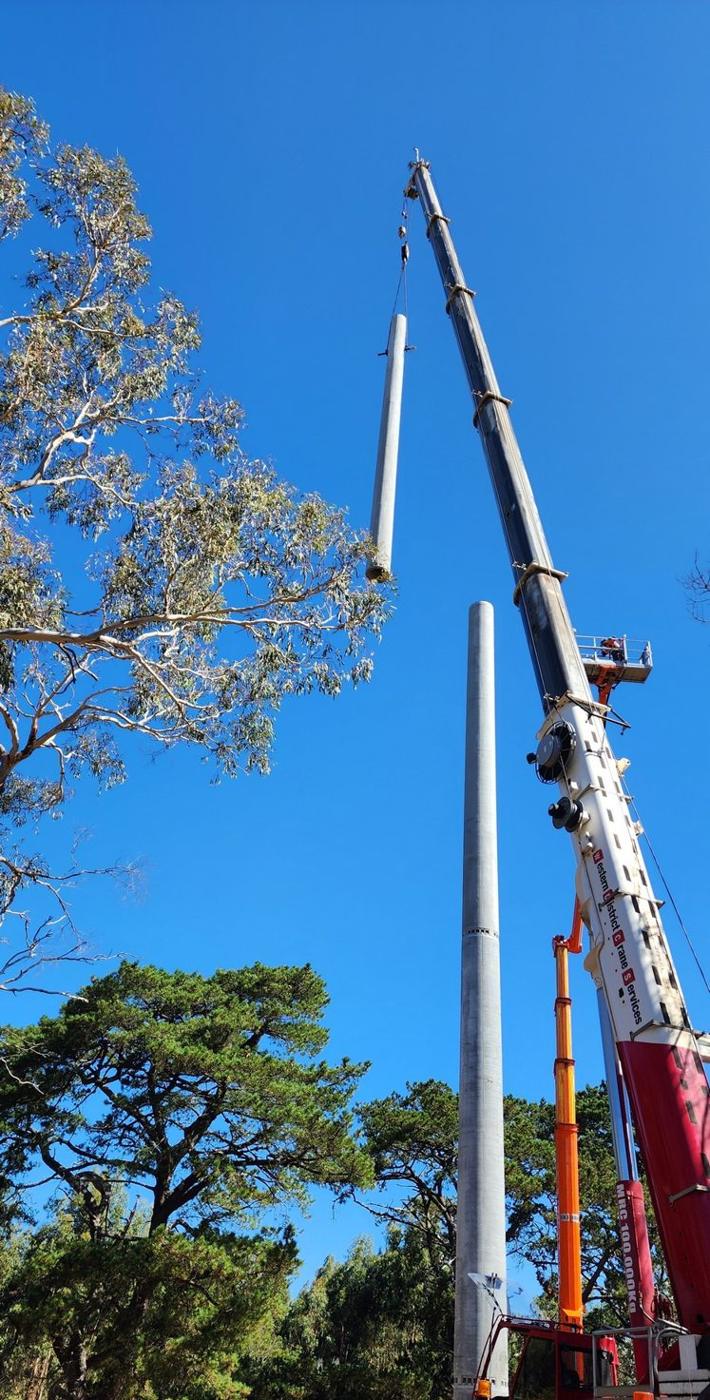 Crane lifting a monopole section into place